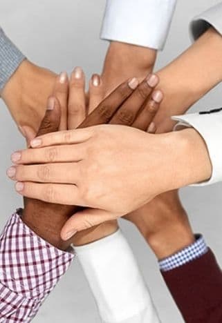 Hands of a diverse professional team joined together, representing partnership
